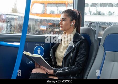 Woman travelling on a bus and looking out of the window Stock Photo