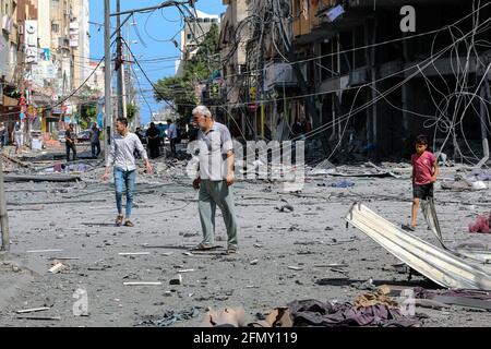 Gaza, Palestine. 12th May, 2021. A Palestinian man walks at the rubble of the severely damaged Al-Jawhara Tower in Gaza City after it was hit by Israeli airstrikes amid the escalating flare-up of Israeli-Palestinian violence. The Health Ministry in the Hamas-run Gaza Strip said the number of Palestinians killed has risen to 35, including 12 children, while 233 people were reported injured. Credit: SOPA Images Limited/Alamy Live News Stock Photo