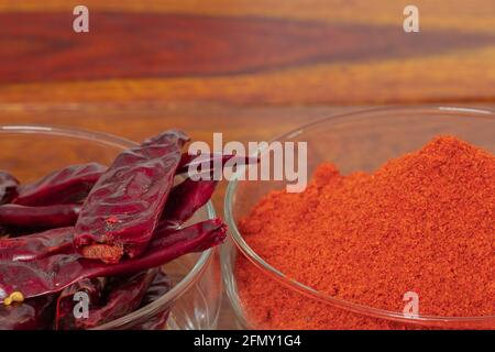 Bowl full of dry red chillies and red chilli powder kept kept side by side with copy space on top Stock Photo