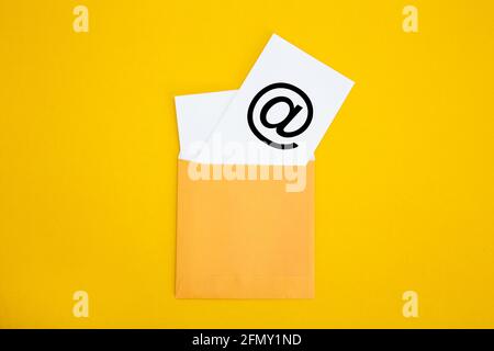 Envelope with email symbol on yellow background - Concept of corporate communication Stock Photo