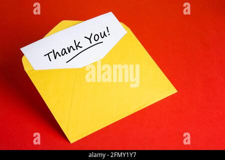Yellow envelope with words THANK YOU on red background Stock Photo