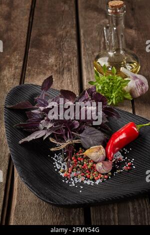 Purple basil with condiments and oil on wooden table Stock Photo