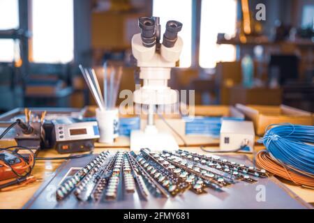 Large electron microscope and panel of LED light indicators are stacked on plate to prepare for the research of electronic components in a laboratory Stock Photo