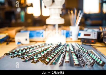 Large electron microscope and panel of LED light indicators are stacked on plate to prepare for the research of electronic components in a laboratory Stock Photo