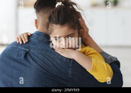 Closeup Portrait Of Upset Little Girl Hugging Daddy At Home Stock Photo