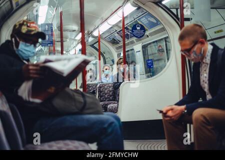 London, UK. 12th May 2021. Passengers on the London Underground wearing masks to help prevent the spread of Covid-19. Whilst numbers of passengers are much lower than before the pandemic, more people are using public transport as the lockdown in England eases. Stock Photo