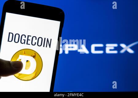 Dogecoin logo on a smartphone against SpaceX logo in the background. SpaceX accepts Dogecoin as payment to launch ‘DOG Stock Photo