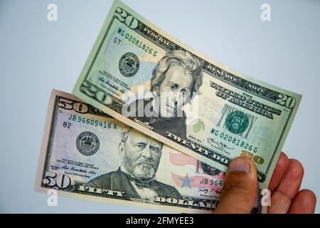 London, UK. 12th May, 2021. In this photo illustration, a person holds a collection of twenty and fifty Dollar banknotes. (Photo by Dinendra Haria/SOPA Images/Sipa USA) Credit: Sipa USA/Alamy Live News Stock Photo