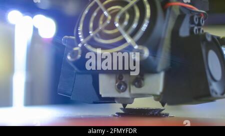 Modern 3D printer machine printing plastic model at exhibition - close up Stock Photo