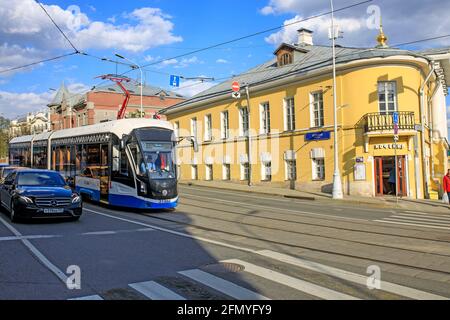 Moscow, Russia - 08 May, 2021, A tram and a car are waiting for green light against the background of ancient buildings in the Taganka district, near Stock Photo