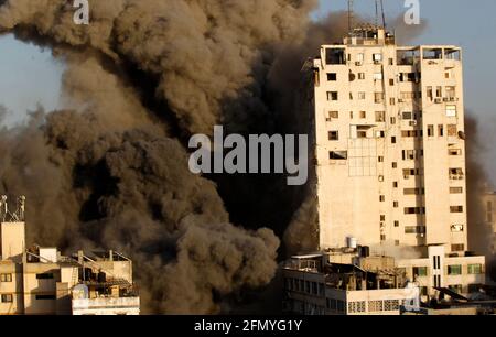 Gaza, Palestine. 12th May, 2021. Smoke rises from a tower building destroyed by Israeli air strikes amid a flare-up of Israeli-Palestinian violence in Gaza CityIsrael carried out hundreds of air strikes in Gaza on Wednesday and Palestinian militants fired multiple rocket barrages at tel aviv and the southern city of Beersheba in the region's most intense hostilities in years. (Photo by Ahmed Zakot/SOPA Images/Sipa USA) Credit: Sipa USA/Alamy Live News Stock Photo