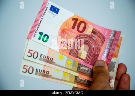 London, UK. 12th May, 2021. In this photo illustration, a person holds a collection of ten and fifty Euro banknotes. Credit: Dinendra Haria/SOPA Images/ZUMA Wire/Alamy Live News Stock Photo