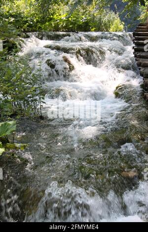 Water flowing freely over rocks and grasses in the Plitvice lakes in central Croatia Stock Photo