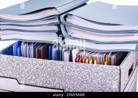 Documents and files folders are placed in a paper box and pile of extra file folders on top. Isolated Stock Photo