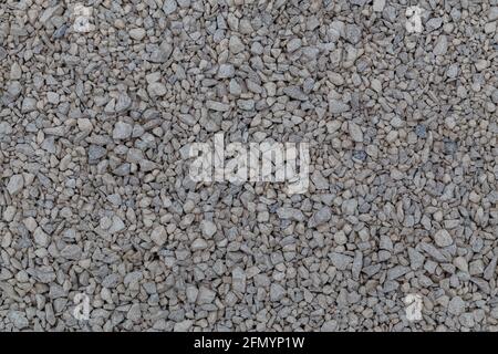 Dry white limestone ballast flat full frame background. Small gray dusty broken macadam stones texture. Viiew from above. Stock Photo