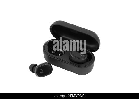 Modern wireless earbuds headphones lying in a charging case isolated on white background. Stock Photo