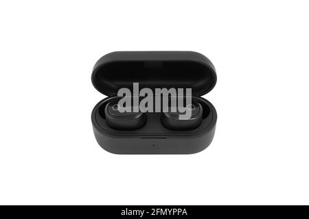 Modern black wireless earbuds headphones lying in charge case isolated on white background. Stock Photo