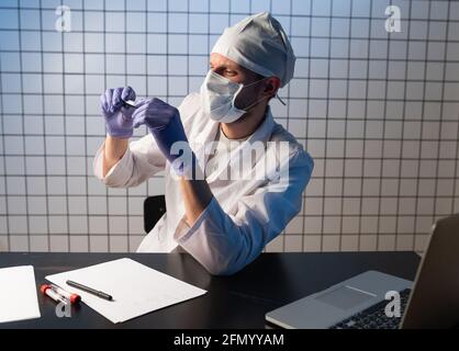 medicine, people and healthcare concept - close up of male doctor writing medical report to clipboard at hospital Stock Photo