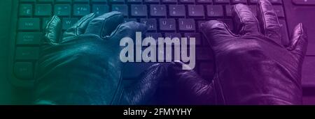 Cybercriminal, hands in gloves on laptop keyboard, photo toned in neon light. Stock Photo