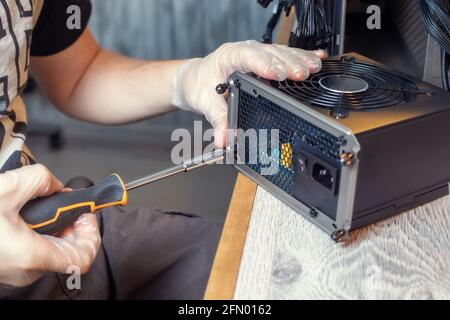 Installing Power Supply Unit into the desktop PC system unit. Computer components. PC assemble Stock Photo
