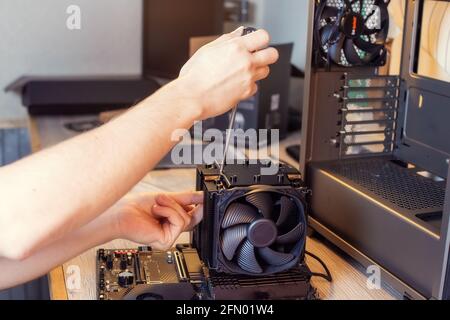 Installing a cooler on a personal computer processor. The process of upgrading computer maintenance in a service Stock Photo