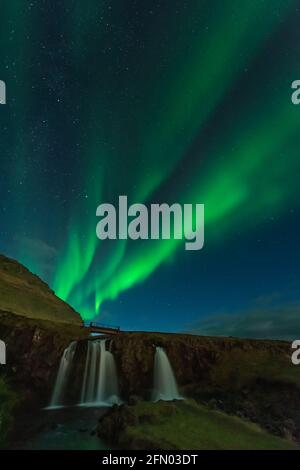 Amazing view of green aurora borealis shining in night sky over snowy ...