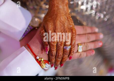 Lady with Mehendi or henna on her hands exchanging an engagement ring, a  ritual which takes place before Hindu wedding. Pune, Maharashtra. -  SuperStock