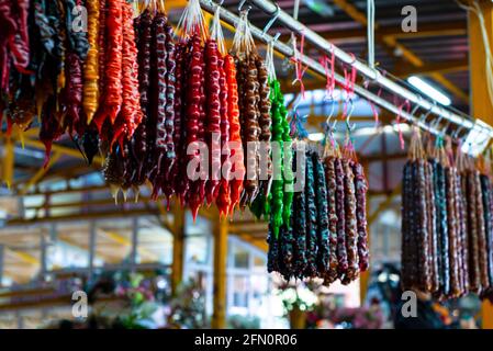Churchkhela at the bazaar. Colored oriental sweets made from nuts and natural juice. Stock Photo