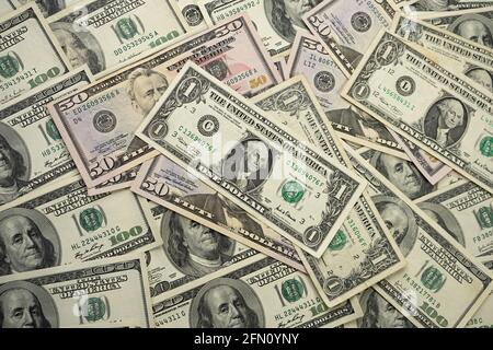 A money pile of various US banknotes with president Washington portrait on top. Cash of dollar bills, paper currency background. Stock Photo
