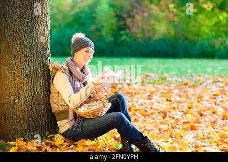 Woman reading book on mushroom foray Stock Photo