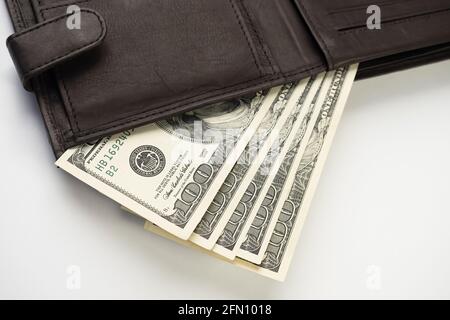 Leather wallet full of money on white background - fan of one hundred US banknotes with president Franklin portrait. Cash of hundred dollar bills, pap Stock Photo