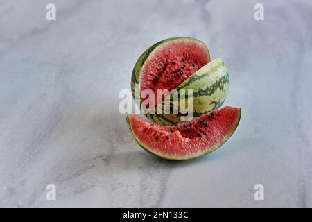 Broken ripe watermelon on a white texture background Stock Photo