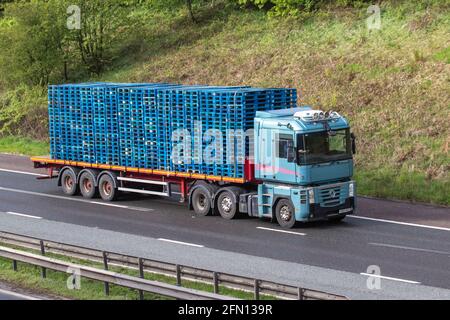 Stacked Wooden blue pallets on Renaulkt HGV vehicle; Heavy goods & commercial traffic on the M61 southbound, UK Stock Photo