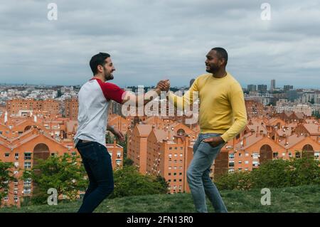 Interracial friends talking and laughing in a park Stock Photo