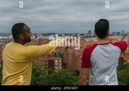 Interracial friends talking and laughing in a park Stock Photo