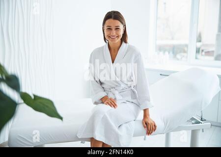 Pleased client sitting on the couch before a cosmetic procedure Stock Photo
