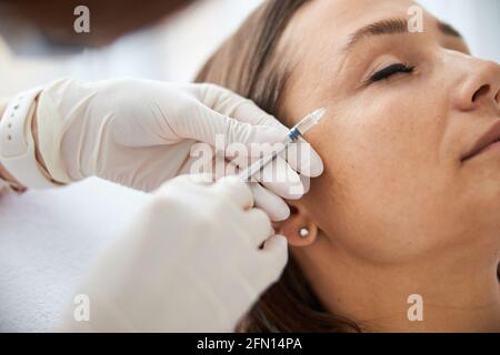 Dark-haired Caucasian woman undergoing a mesotherapy procedure Stock Photo