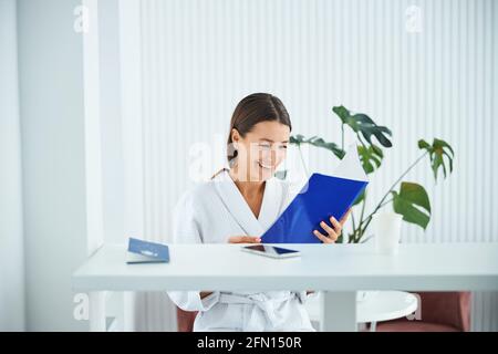Merry young female reading the information about a wellness center Stock Photo