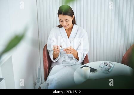 Smiling woman examining a mini chocolate bar in her hands Stock Photo