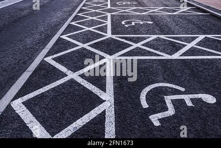 Disabled parking spaces painted on a tarmac road Stock Photo