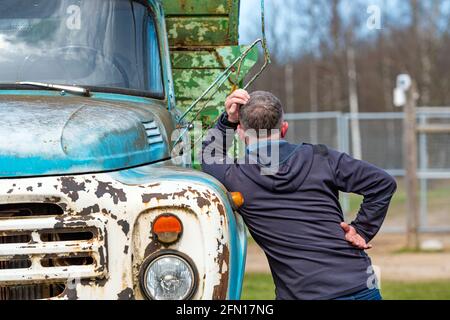 Gulbene, Latvia - May 02, 2021: man at the vintage Soviet truck ZIL 130 in the village, close-up, a man from behind Stock Photo