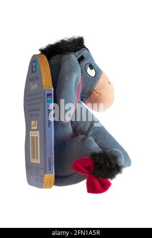 Winnie the Pooh Friendly Tales Eeyore soft cuddly plush toy attached to book isolated on white background Stock Photo