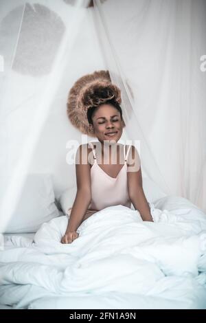 Happy african american woman in sleepwear with closed eyes Stock Photo