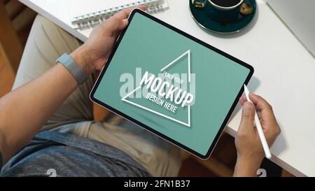 Overhead shot of male office worker working with mock up digital tablet while relaxed sitting at workplace Stock Photo