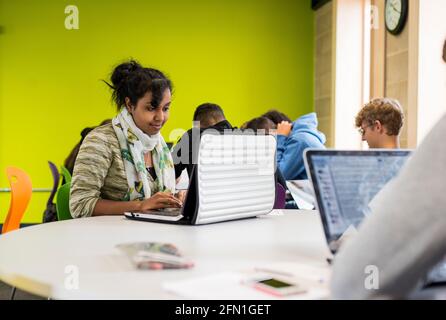 Female black sixth form student, young female in UK education, teenage girl looking at laptop, Indian female student working at laptop, student Stock Photo