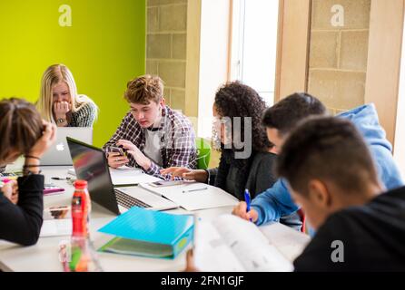 Multicultural sixth form students, young people in education, teenagers looking at laptop in sixth form, students working, studying before COVID-19 Stock Photo