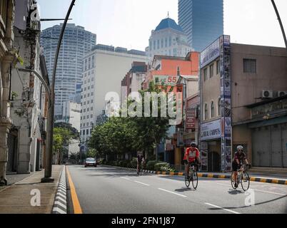 Kuala Lumpur, Malaysia. 13th May, 2021. Bicycle riders ride along an empty street during the first day of the Hari Raya celebrations. Malaysia's Prime Minister Muhyiddin Yassin has announced that the whole of Malaysia will be placed under the Movement Control Order (MCO) from May 12 to June 7, 2021, due to the rising of Covid-19 infections. Credit: SOPA Images Limited/Alamy Live News Stock Photo
