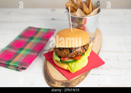 Homemade veggie burger in a brioche bun with a side of chips Stock Photo