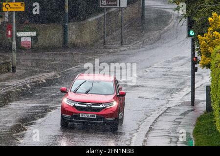 Chippenham, Wiltshire, UK, 13th May, 2021. Car drivers are pictured driving in heavy rain in Chippenham as heavy rain showers make their way across Southern England. Credit: Lynchpics/Alamy Live News Stock Photo