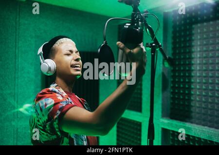 Woman singer recording new music album inside boutique studio - Focus on face Stock Photo